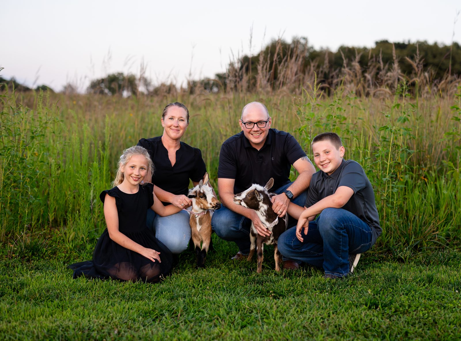 The Teshka family with their goats in the prairie at home in northern Indiana